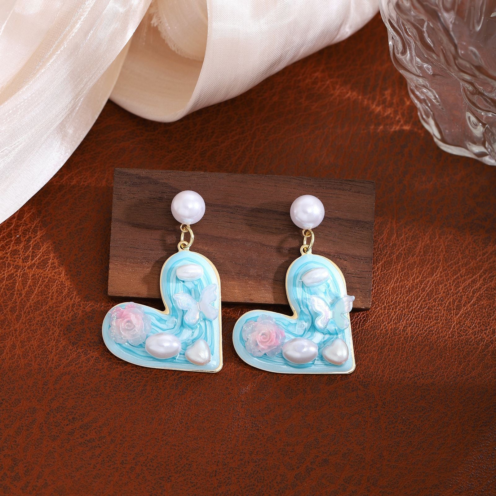 Light blue heart-shaped drop earrings with pearl, rose and butterfly details