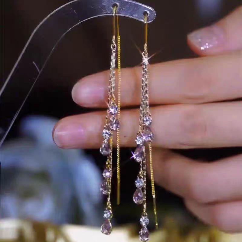 Purple crystal tassel ear line earrings on display stand, gold finish
