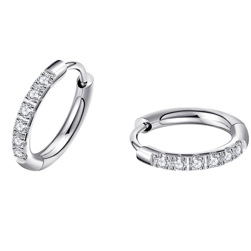 Close-up view of silver titanium steel hoop earrings with zirconia stones